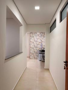 a hallway with white walls and a hallway with a table at Hospedaria Santa Inês in Cachoeira Paulista