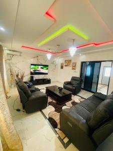 a living room with black leather furniture and a star on the ceiling at Sowe's Villa in Old Yundum