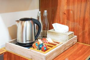 a tray with a tea kettle on a counter at Naeco Select Pearl in Hanimaadhoo