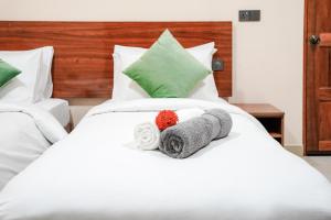 a bed with two towels and a stuffed animal on it at Naeco Select Pearl in Hanimaadhoo