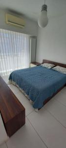 a bedroom with a bed with a blue comforter at ORAN App in Dherinia