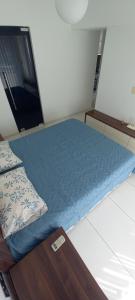 a bed in a room with a blue comforter at ORAN App in Dherinia +2 photos