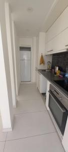 a kitchen with white cabinets and a white floor at ORAN App in Dherinia