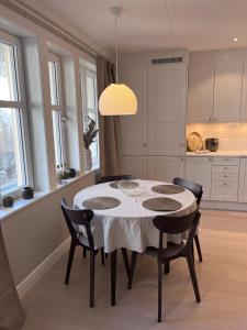 a kitchen with a table with chairs and a light fixture at Fjallbacka, Modern nyproducerad lägenhet med egen parkering och laddning in Fjällbacka