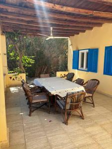 a dining table and chairs on a patio at فيلا كوكو بقرية تونس in Tunis