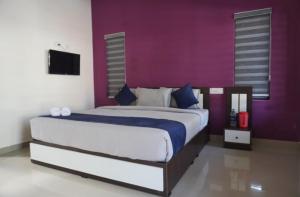 a bedroom with a large bed with a purple wall at Mount Ocio Pool Resort Wayanad, Chulliyode in Ambalavayal +22 photos
