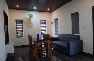 a living room with a couch and a table and chairs at Mount Ocio Pool Resort Wayanad, Chulliyode in Ambalavayal