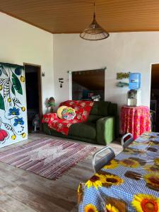 a living room with a green couch and a table at Casa Velha Hospedagem Jacuípe in Camaçari