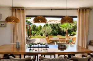 a dining room with a table and a patio at Villa Rosa, 4chambres, piscine , Lecci , 8 personnes in Lecci