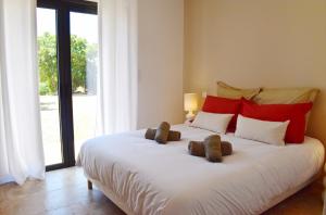 a large white bed with two teddy bears on it at Villa Rosa, 4chambres, piscine , Lecci , 8 personnes in Lecci