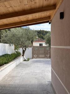 an entrance to a house with a wooden pergola at Zac's Rooms in Dukat