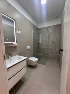 a bathroom with a sink and a toilet and a shower at Zac's Rooms in Dukat +15 photos