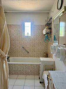 a bathroom with a tub and a sink at La Maison de Marianne in Fleury