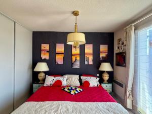 a bedroom with a large bed with a red blanket at La Maison de Marianne in Fleury