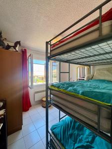 a bedroom with two bunk beds and a window at La Maison de Marianne in Fleury +4 photos