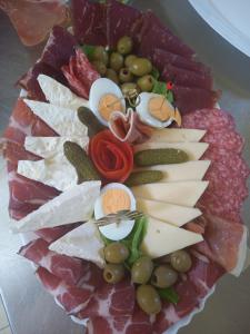 a plate of different types of cheese and vegetables at Vila Milena in Žabljak +7 photos