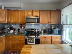 a kitchen with wooden cabinets and a stove top oven at Classical American House 4 in Brooklyn