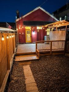 a house with a wooden porch with lights on it at Historic Main St Apt | Private Garage in St. Charles