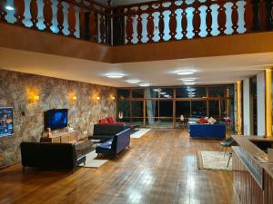 a large living room with a couch and a tv at Hotel Tijuco Turismo in Diamantina