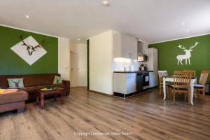 a living room with a couch and a table and a kitchen at Naturhotel Hof Ehlers in Bergen