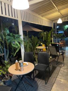 an outdoor patio with tables and chairs and plants at Hidden courtyard in Ban Bang Phun
