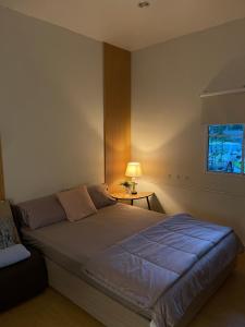 a bedroom with a large bed with a window at Hidden courtyard in Ban Bang Phun
