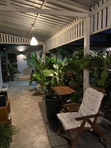 a room with a chair and a lot of plants at Hidden courtyard in Ban Bang Phun
