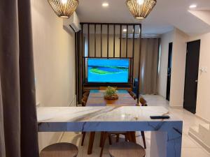 a living room with a table and a television at Casa Cielo del Mar in Ciudad Madero