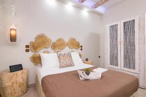 a white bedroom with a large bed and a table at Villa Ioanna in Potos