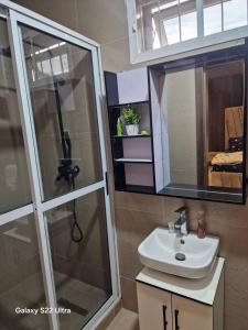 a bathroom with a sink and a shower with a mirror at NestNov in Aguda