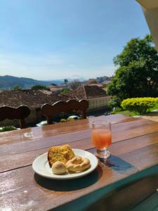 a plate of bread and a glass of orange juice at Hotel Tijuco Turismo in Diamantina