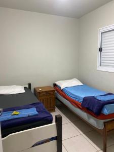 a bedroom with two beds and a window at Espaço Vida Nova in Lins