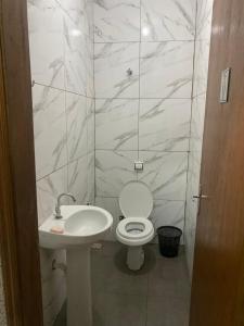 a bathroom with a white toilet and a sink at Espaço Vida Nova in Lins +7 photos