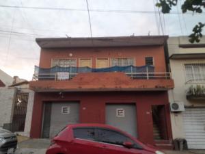 a red house with a red car parked in front of it at Tata Róga in Asunción