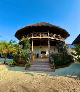 a house with a thatched roof on the beach at Gavana House in Mfumbwi