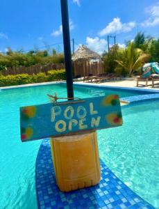 a sign that reads pool open next to a swimming pool at Gavana House in Mfumbwi