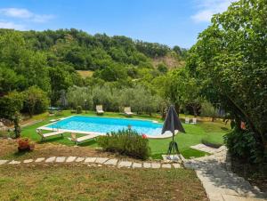 a swimming pool in a yard with chairs and an umbrella at Casale Santilli in Agnone