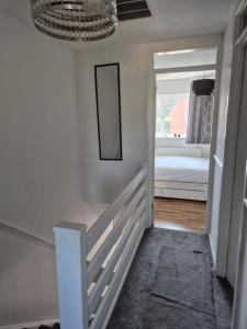 a hallway with a mirror and a bed in a room at 2BR home in Twickenham in Hounslow