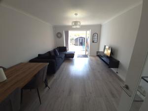 a living room with a couch and a table at 2BR home in Twickenham in Hounslow