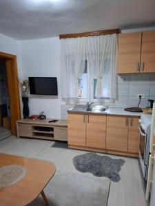 a kitchen with wooden cabinets and a sink at Apartman Mostar in Mostar