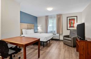 a hotel room with a bed and a desk at Extended Stay America Suites - Fort Wayne - North in Fort Wayne