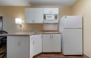 a kitchen with white cabinets and a white refrigerator at Extended Stay America Suites - Sacramento - White Rock Rd in Rancho Cordova