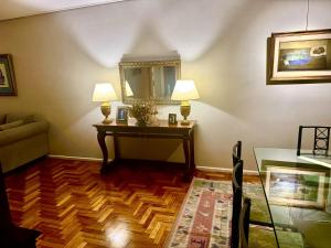 a living room with two lamps and a table with a mirror at Avenida Las Heraas in Buenos Aires +28 photos