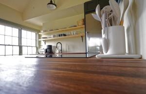 a kitchen with a vase of flowers on a wooden floor at Whitford House Cottage in Addison
