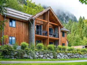 a log home with a stone retaining wall at Seeblick am Pressegger See in Lake Pressegg