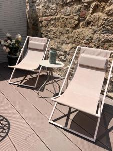 two chairs and a table on a patio at Stadtmauerloft - Premium Apartment in Eisenstadt