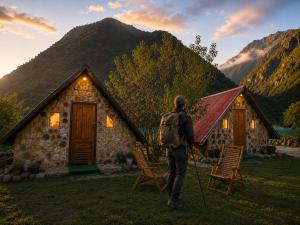 a man with a backpack standing in front of a cabin at Ebenezer Salkantay Huts in Colcapampa