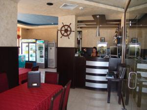 a restaurant with a woman sitting at a counter at Hotel Buena Vissta in Primorsko