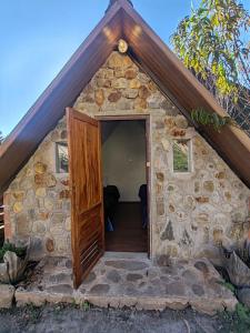 a small stone house with a wooden door at Ebenezer Salkantay Huts in Colcapampa
