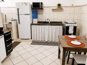 a kitchen with a table and a refrigerator at Bela vista a beira mar in Marataizes +17 photos
